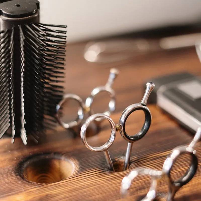 Salon scissors and a hairbrush laid out on a wooden counter