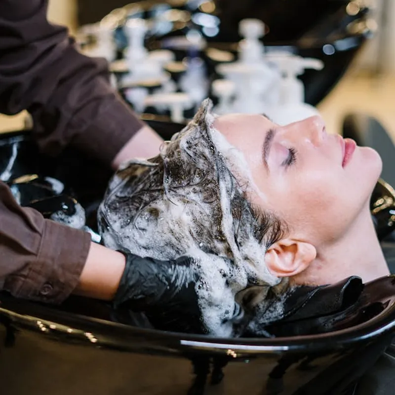 A client having their hair washed at the salon basin